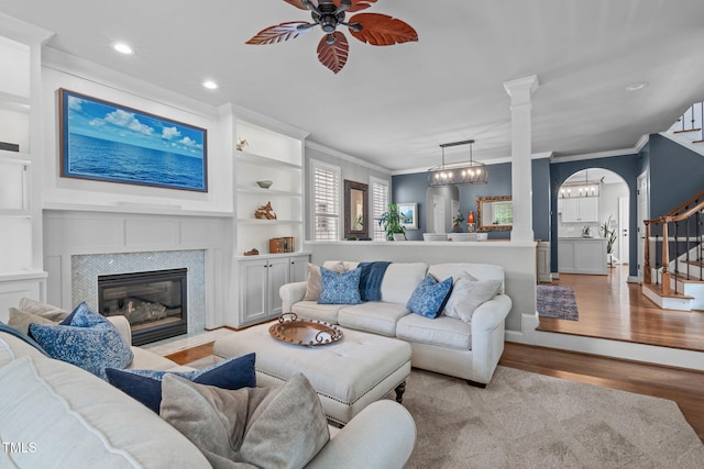 321 Commons Walk Cir, Cary, NC 27519 - living room featuring crown molding, stairway, light wood finished floors, ceiling fan, and a tile fireplace