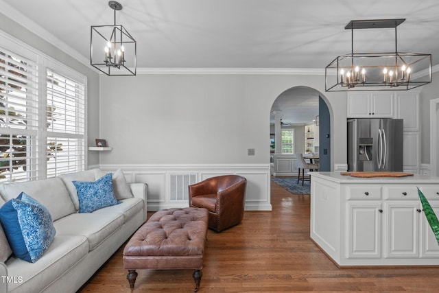 321 Commons Walk Cir, Cary, NC 27519 - living room featuring a chandelier, arched walkways, ornamental molding, a wainscoted wall, and wood finished floors