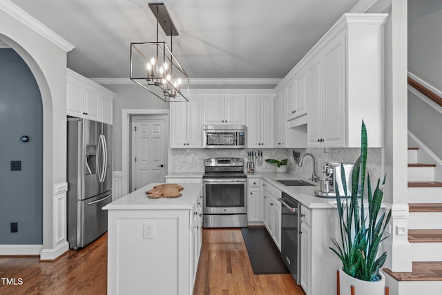 321 Commons Walk Cir, Cary, NC 27519 - kitchen with stainless steel appliances, a sink, white cabinetry, light countertops, and ornamental molding