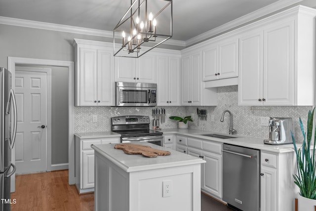 321 Commons Walk Cir, Cary, NC 27519 - kitchen featuring stainless steel appliances, a sink, white cabinets, ornamental molding, and a chandelier