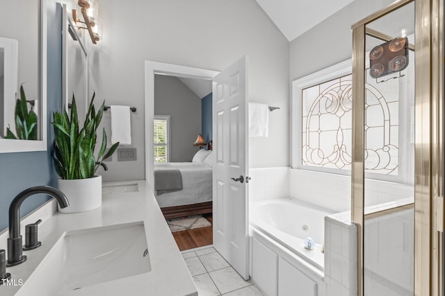 321 Commons Walk Cir, Cary, NC 27519 - bathroom with vaulted ceiling, a whirlpool tub, double vanity, marble look tile flooring, and ensuite bath
