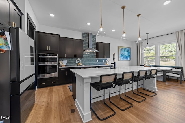 105 Scotland Dr, Youngsville, NC 27596 - kitchen featuring wall chimney range hood, a sink, fridge, light wood finished floors, and light countertops