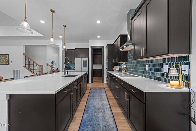 105 Scotland Dr, Youngsville, NC 27596 - kitchen featuring a sink, black electric cooktop, light wood-style flooring, tasteful backsplash, and recessed lighting