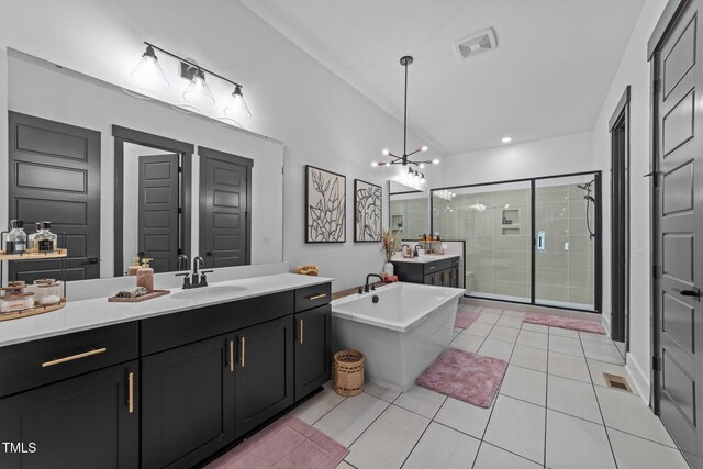 105 Scotland Dr, Youngsville, NC 27596 - full bathroom with a shower stall, two vanities, a soaking tub, a chandelier, and tile patterned flooring
