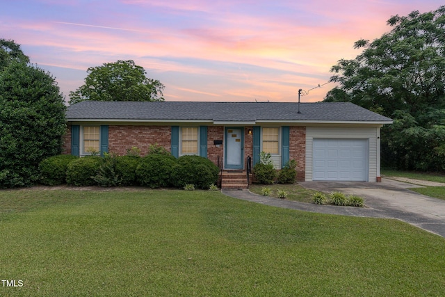 1304 Park Ave, Dunn, NC 28334 - ranch-style house with a garage, driveway, a yard, brick siding, and a shingled roof