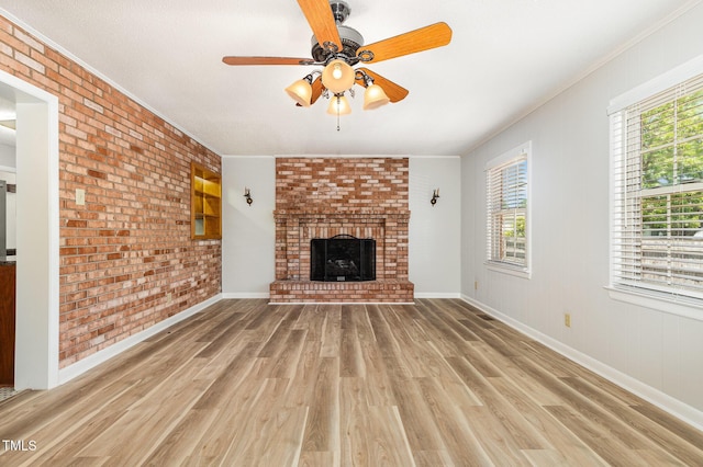1304 Park Ave, Dunn, NC 28334 - unfurnished living room with light wood-style floors, brick wall, crown molding, a ceiling fan, and a brick fireplace