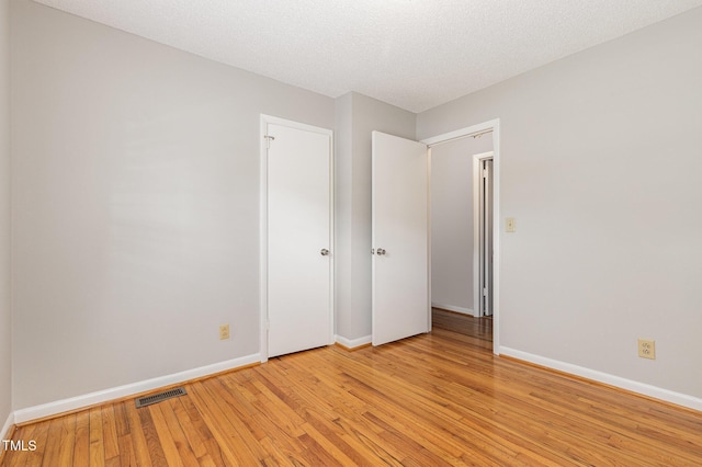 1304 Park Ave, Dunn, NC 28334 - unfurnished bedroom featuring baseboards, light wood-style flooring, and a textured ceiling
