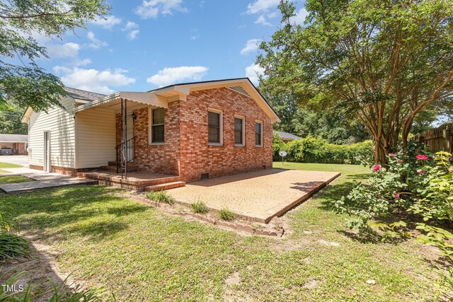 1304 Park Ave, Dunn, NC 28334 - back of house featuring brick siding, crawl space, and a patio
