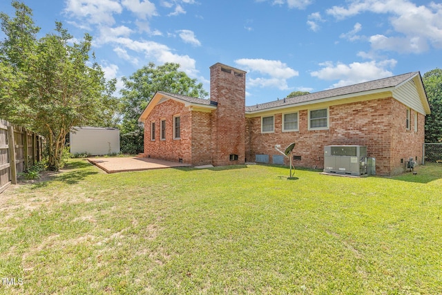 1304 Park Ave, Dunn, NC 28334 - back of house featuring brick siding, cooling unit, a chimney, and a patio area