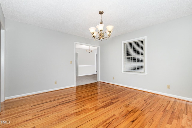 1304 Park Ave, Dunn, NC 28334 - unfurnished room with a chandelier, wood finished floors, baseboards, and a textured ceiling