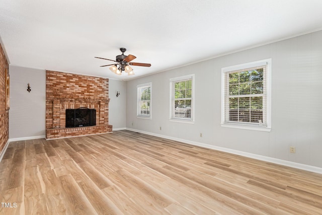1304 Park Ave, Dunn, NC 28334 - unfurnished living room with a ceiling fan, light wood-style flooring, a brick fireplace, baseboards, and ornamental molding