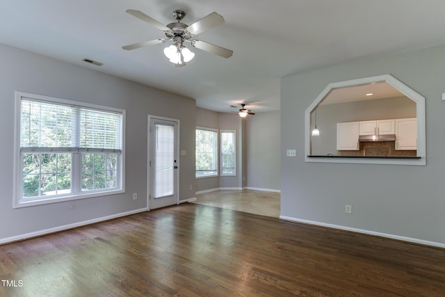 1310 Southgate Dr, Raleigh, NC 27610 - unfurnished living room with a ceiling fan, wood finished floors, and baseboards