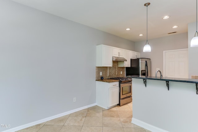 1310 Southgate Dr, Raleigh, NC 27610 - kitchen with appliances with stainless steel finishes, a breakfast bar area, tasteful backsplash, hanging light fixtures, and white cabinetry