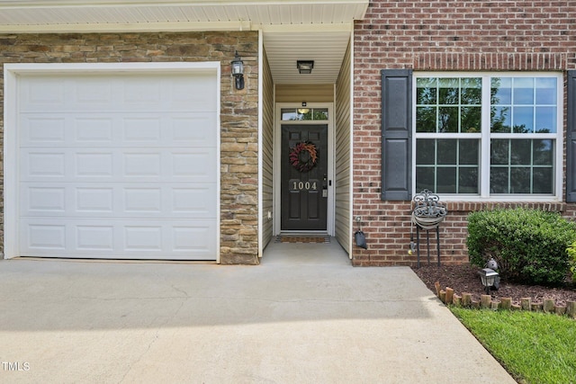 1004 Lake Michael Way, Mebane, NC 27302 - view of exterior entry with brick siding, driveway, stone siding, and an attached garage