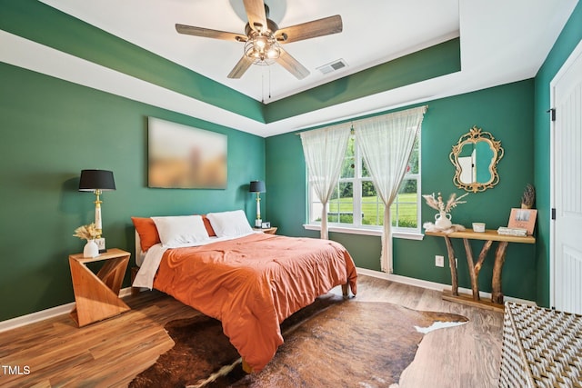 1004 Lake Michael Way, Mebane, NC 27302 - bedroom with baseboards, wood finished floors, a tray ceiling, and a ceiling fan