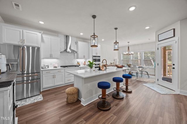 232 Duncan Creek Rd, Lillington, NC 27546 - kitchen featuring wall chimney exhaust hood, stainless steel appliances, wood finished floors, white cabinets, and recessed lighting