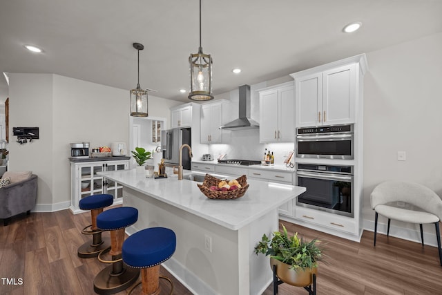 232 Duncan Creek Rd, Lillington, NC 27546 - kitchen featuring wall chimney range hood, stainless steel appliances, a center island with sink, a breakfast bar area, and recessed lighting
