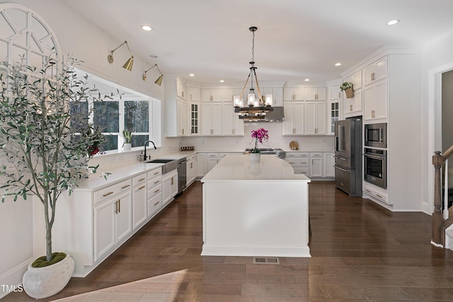 1475 Sierra Glen Cir, Apex, NC 27502 - kitchen with appliances with stainless steel finishes, a sink, a chandelier, light countertops, and white cabinets