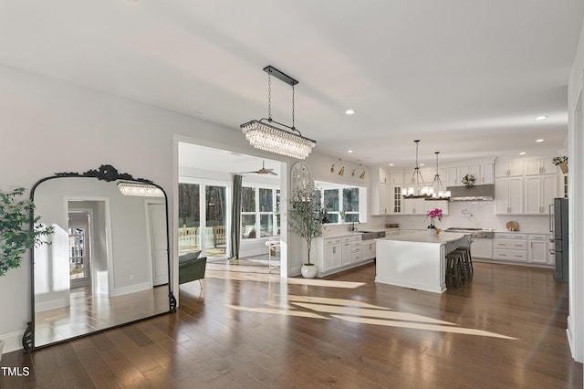 1475 Sierra Glen Cir, Apex, NC 27502 - kitchen with appliances with stainless steel finishes, a sink, a kitchen island, white cabinetry, and tasteful backsplash