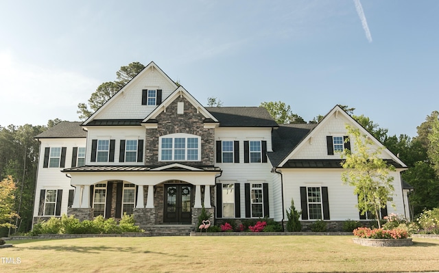 1475 Sierra Glen Cir, Apex, NC 27502 - craftsman-style house featuring french doors, a front lawn, a standing seam roof, stone siding, and a porch