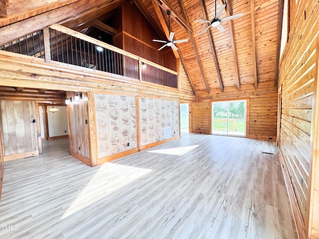 1283 Ennis Rd, Angier, NC 27501 - unfurnished living room featuring high vaulted ceiling, wooden walls, wooden ceiling with exposed beams, wood finished floors, and a ceiling fan