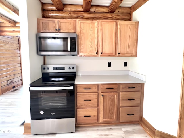 1283 Ennis Rd, Angier, NC 27501 - kitchen featuring appliances with stainless steel finishes, light wood-style floors, light countertops, beam ceiling, and light brown cabinets