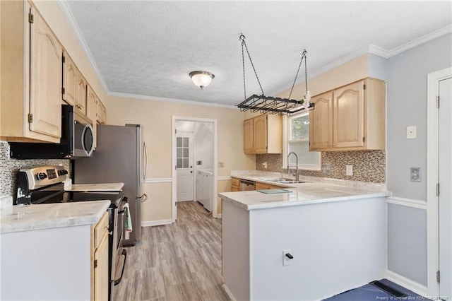 1266 Exeter Ln, Fayetteville, NC 28314 - kitchen with stainless steel appliances, light brown cabinets, a sink, washing machine and clothes dryer, and light countertops
