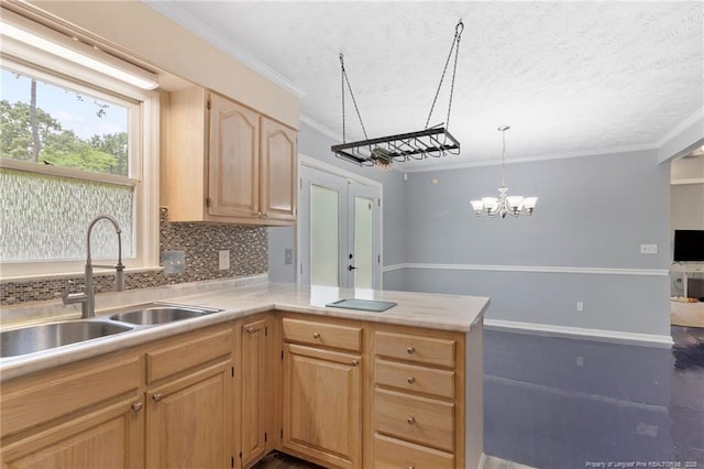 1266 Exeter Ln, Fayetteville, NC 28314 - kitchen featuring a sink, tasteful backsplash, light countertops, ornamental molding, and a chandelier