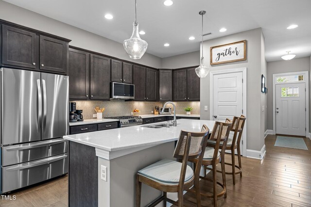 78 Salt Cedar Ln, Chapel Hill, NC 27516 - kitchen featuring appliances with stainless steel finishes, a sink, dark brown cabinets, a breakfast bar area, and backsplash