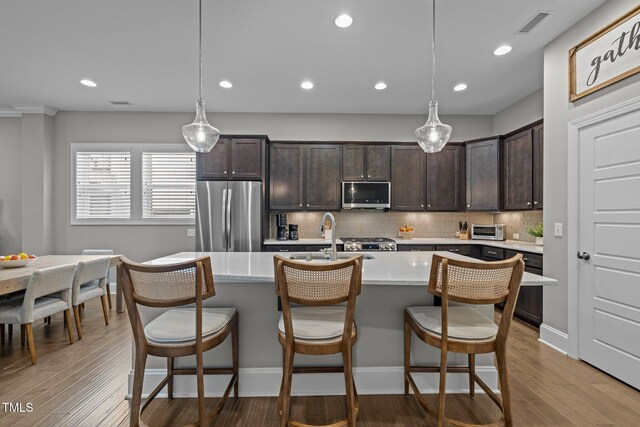 78 Salt Cedar Ln, Chapel Hill, NC 27516 - kitchen with appliances with stainless steel finishes, dark brown cabinetry, tasteful backsplash, a sink, and wood finished floors
