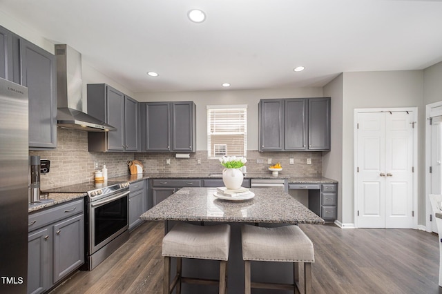 1211 Whispering Oak Ln, Durham, NC 27704 - kitchen featuring wall chimney exhaust hood, appliances with stainless steel finishes, gray cabinetry, decorative backsplash, and dark wood-style floors