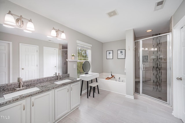 1211 Whispering Oak Ln, Durham, NC 27704 - bathroom featuring a shower stall, a garden tub, double vanity, and baseboards