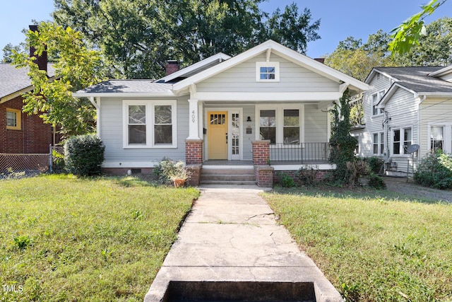 409 N Hyde Park Ave, Durham, NC 27703 - bungalow featuring covered porch, a front lawn, and a chimney