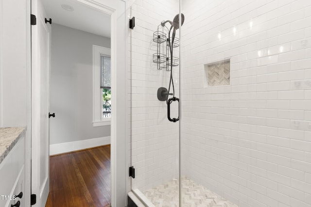 409 N Hyde Park Ave, Durham, NC 27703 - bathroom featuring wood-type flooring, a stall shower, baseboards, and vanity