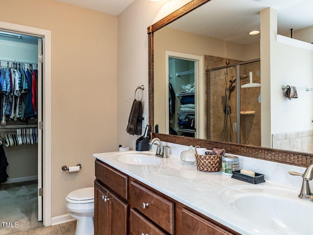 1004 Bridlemine Dr, Fuquay Varina, NC 27526 - bathroom featuring a spacious closet, double vanity, a stall shower, toilet, and tile patterned floors