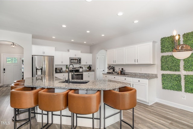 108 Pointe Dr, La Grange, NC 28551 - kitchen featuring stainless steel appliances, a sink, arched walkways, light wood-style flooring, and recessed lighting