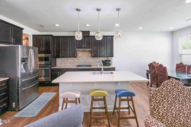 1021 Benay Rd, Morrisville, NC 27560 - kitchen with appliances with stainless steel finishes, a sink, a kitchen bar, light countertops, and tasteful backsplash