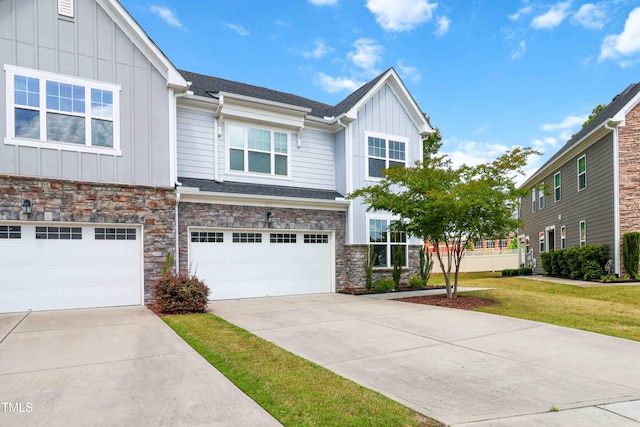 1021 Benay Rd, Morrisville, NC 27560 - view of front of home featuring board and batten siding, concrete driveway, a garage, stone siding, and a front lawn