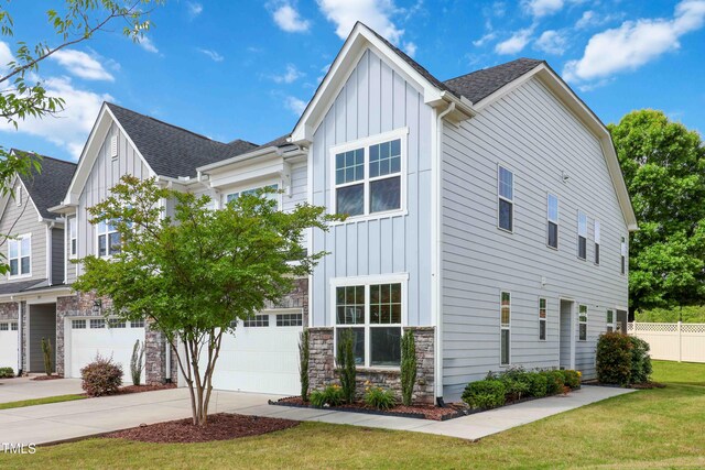1021 Benay Rd, Morrisville, NC 27560 - view of front of house with board and batten siding, an attached garage, roof with shingles, and concrete driveway