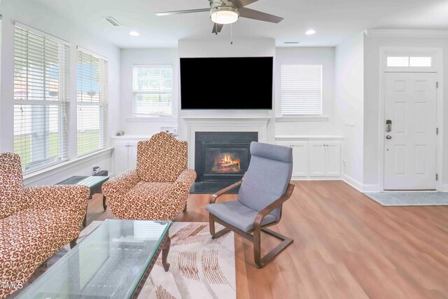 1021 Benay Rd, Morrisville, NC 27560 - living room with light wood-style flooring, a fireplace with flush hearth, ceiling fan, crown molding, and baseboards