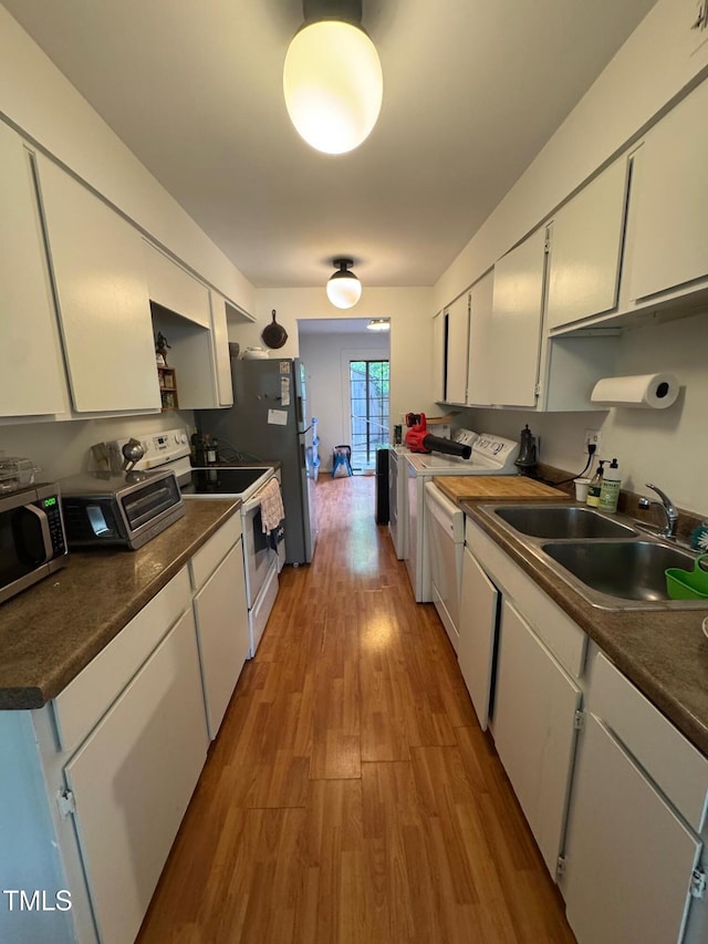 1708 Quail Ridge Rd, Raleigh, NC 27609 - kitchen featuring white electric stove, stainless steel microwave, white cabinets, a sink, and light wood-style floors