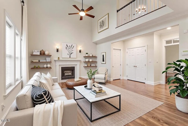 1817 Foxbrook Dr, Raleigh, NC 27603 - living area with a ceiling fan, light wood finished floors, baseboards, a high ceiling, and a fireplace