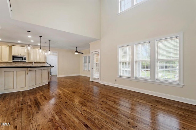 1817 Foxbrook Dr, Raleigh, NC 27603 - unfurnished living room with dark wood-type flooring, baseboards, a ceiling fan, recessed lighting, and a towering ceiling