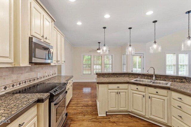 1817 Foxbrook Dr, Raleigh, NC 27603 - kitchen featuring stainless steel appliances, a sink, cream cabinets, wood finished floors, and recessed lighting