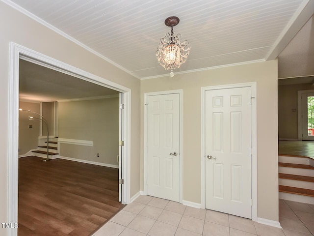 1215 Brookgreen Dr, Cary, NC 27511 - hall featuring stairs, a chandelier, baseboards, light wood finished floors, and crown molding