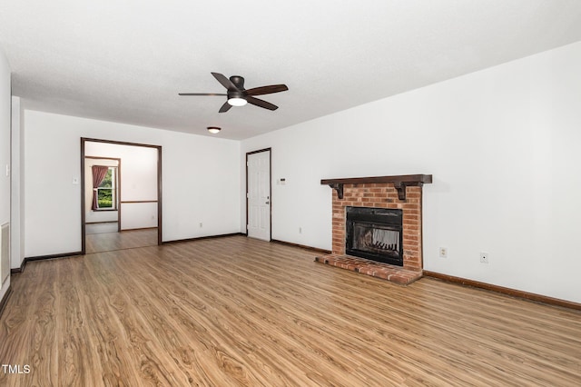 6516 Hearthstone Dr Unit 6516, Raleigh, NC 27615 - unfurnished living room with light wood-style floors, a ceiling fan, a brick fireplace, and baseboards