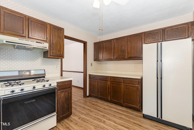 6516 Hearthstone Dr Unit 6516, Raleigh, NC 27615 - kitchen featuring freestanding refrigerator, gas stove, under cabinet range hood, light wood-style floors, and light countertops