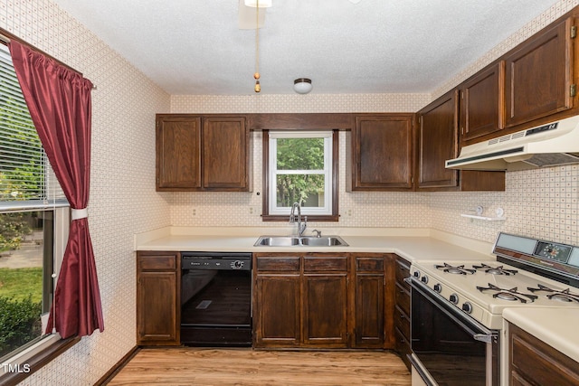 6516 Hearthstone Dr Unit 6516, Raleigh, NC 27615 - kitchen with dishwasher, gas range oven, under cabinet range hood, wallpapered walls, and a sink