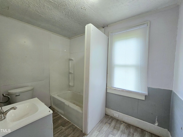1109 N George St, Goldsboro, NC 27530 - bathroom featuring wood finished floors, vanity, a textured ceiling, toilet, and tub / shower combination