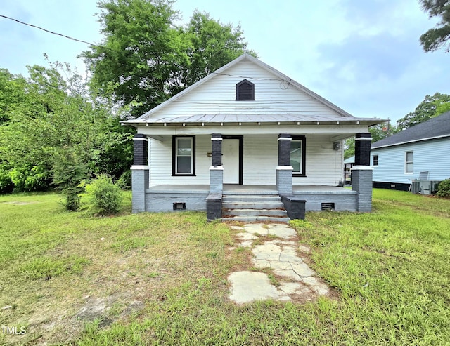 1109 N George St, Goldsboro, NC 27530 - view of front facade with a porch, a front yard, metal roof, and a standing seam roof